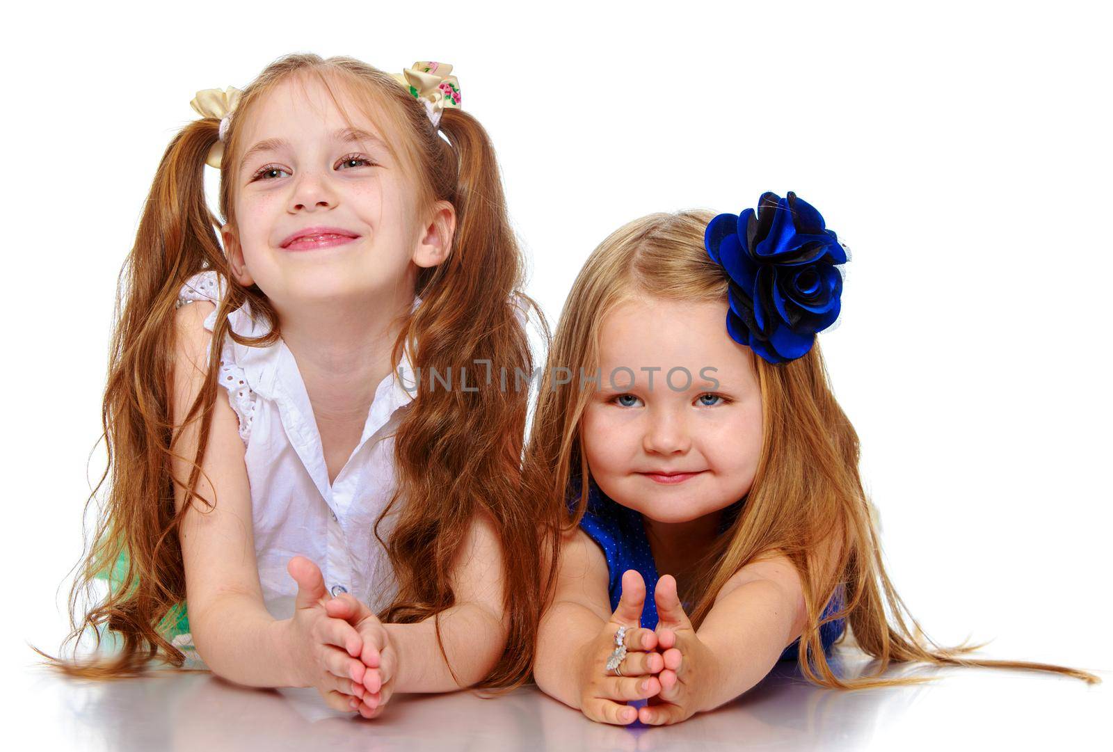 Two beautiful little girls lying on the floor-Isolated on white background