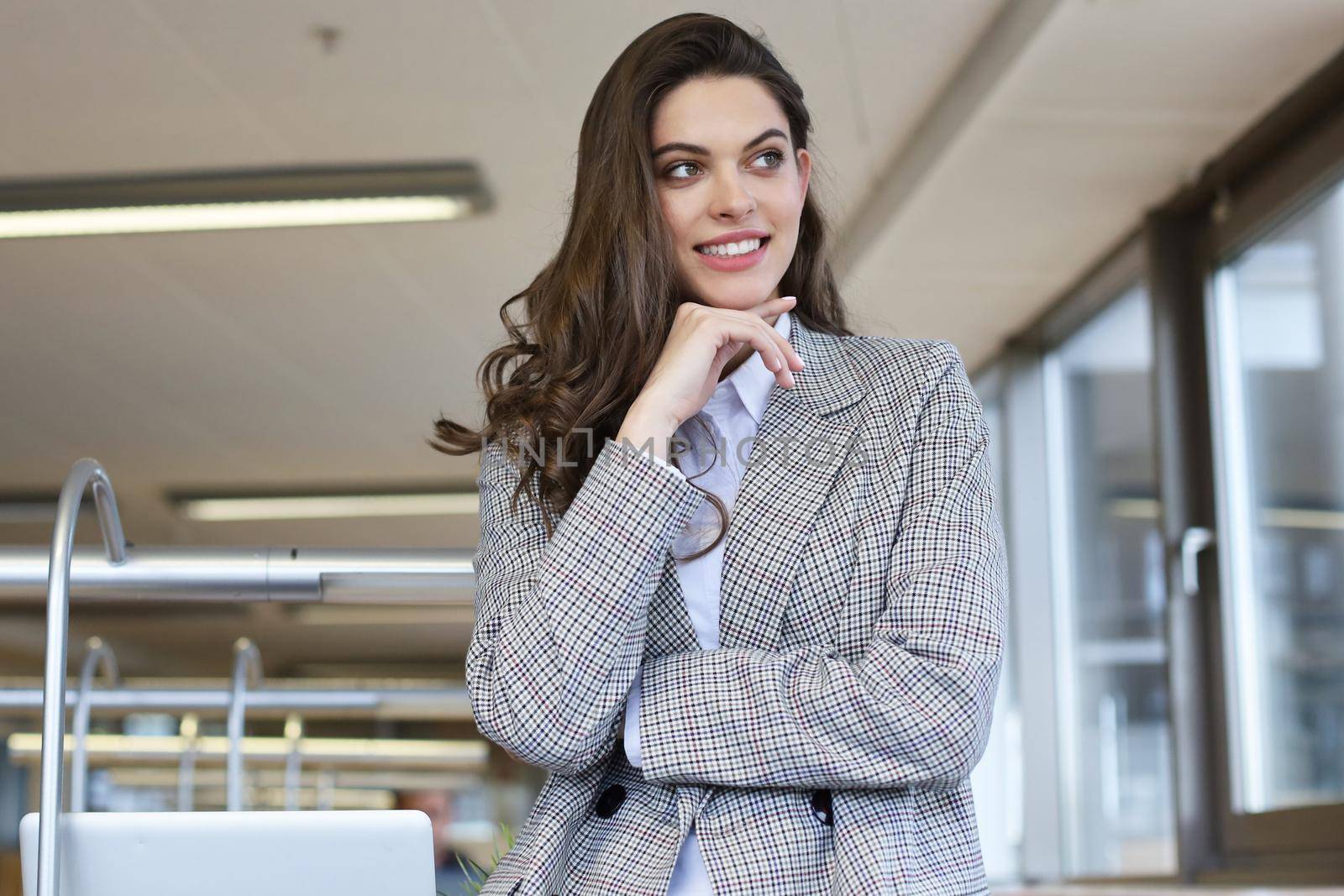 Attractive businesswoman standing near desk in the office