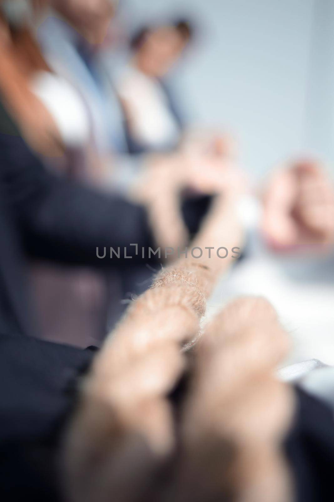 People holding rope together on light background, closeup of hands. Unity concept