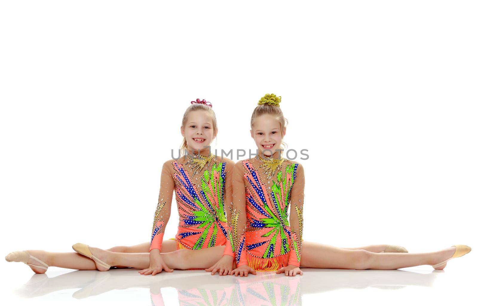 Two girls gymnast sitting on splits. by kolesnikov_studio