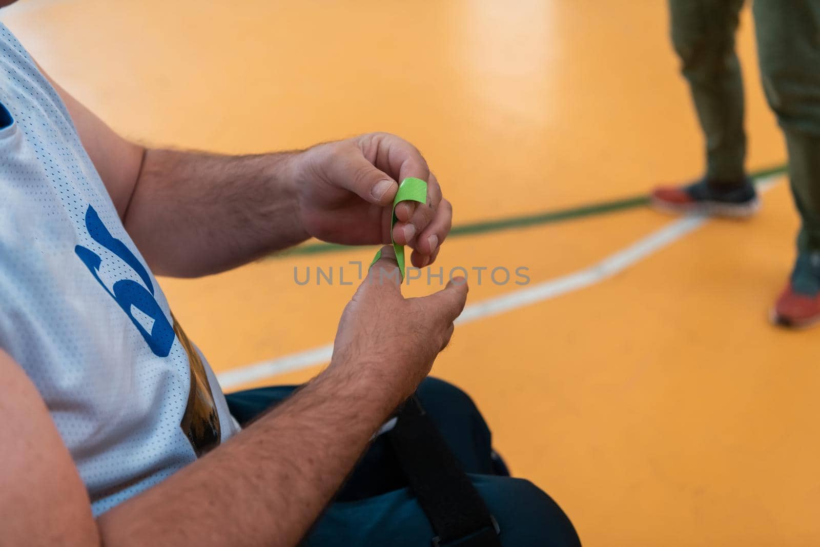 a disabled basketball player puts on a corset and bandages on his arms and fingers in preparation for a game in the arena. Selective focus 