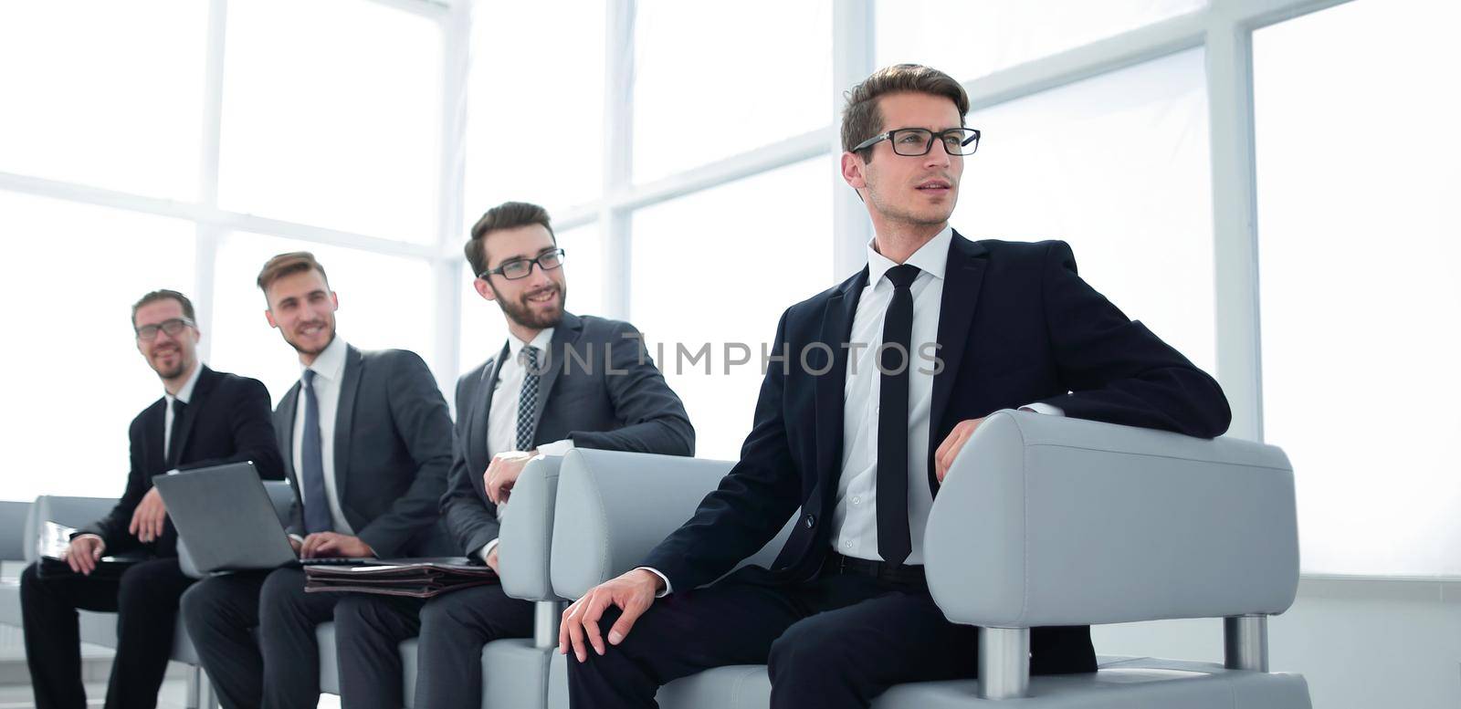 group of young businessmen sitting in the lobby of the business center by asdf