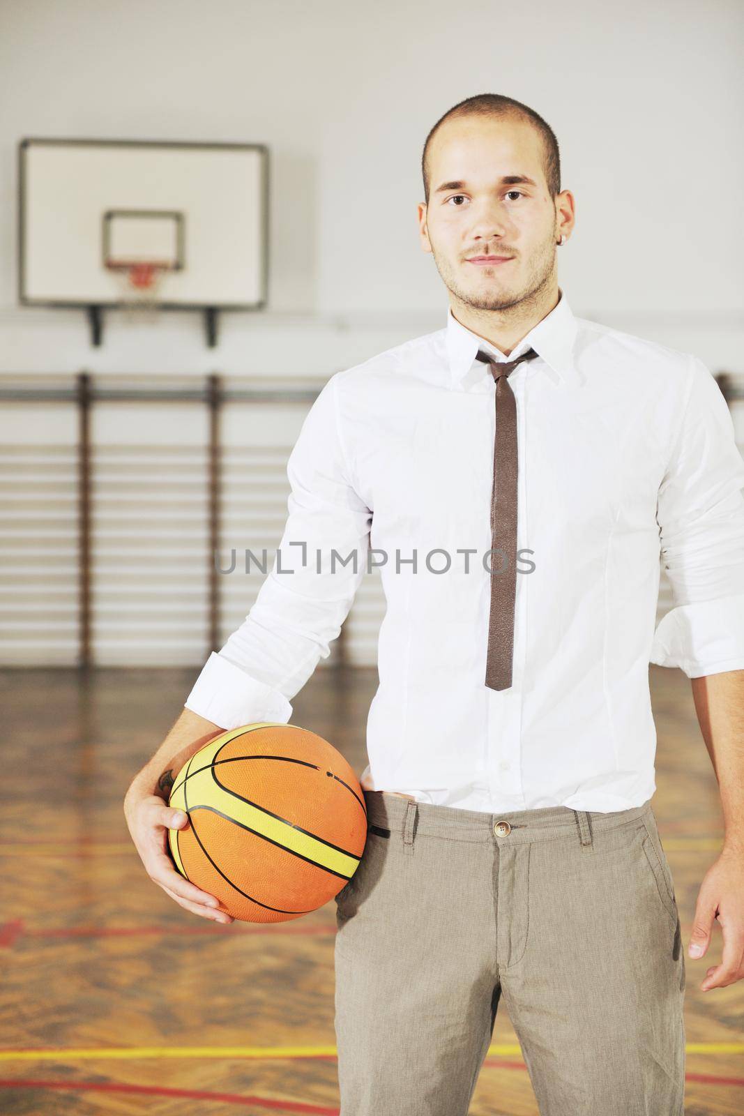 businessman holding basketball ball by dotshock