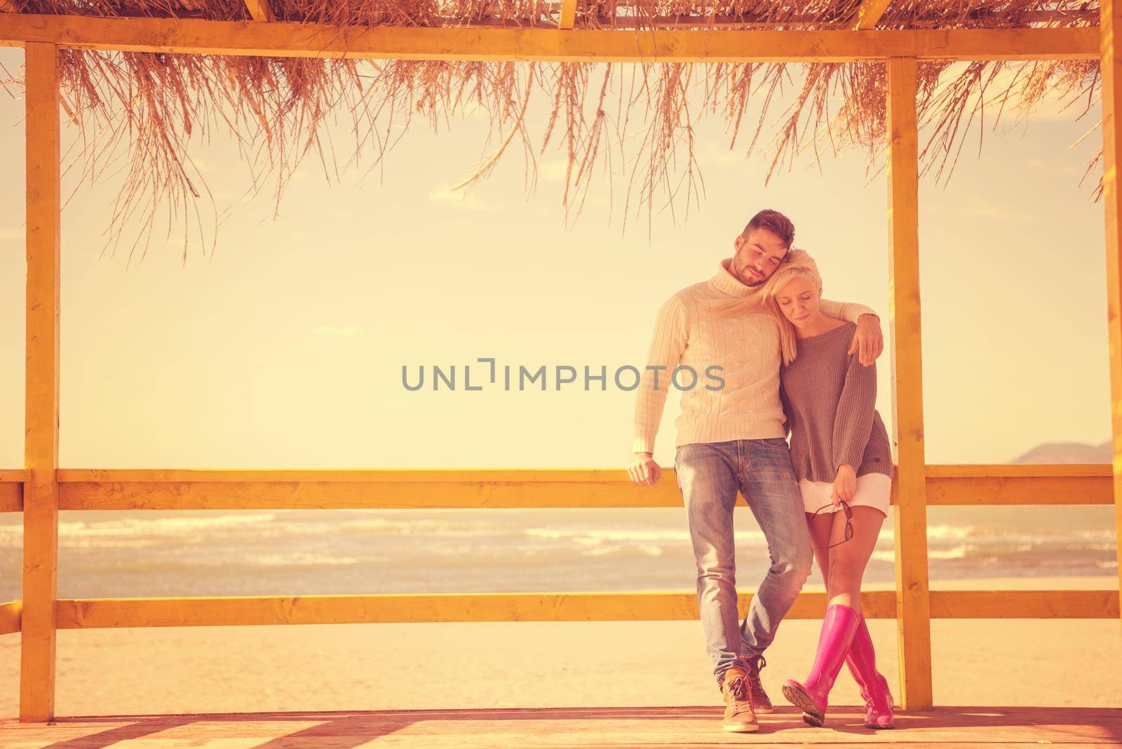 Happy couple enyojing time together on beach during autumn day