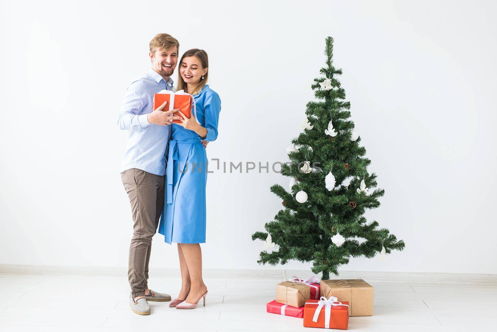 Holidays and celebration concept - Man giving a Christmas present to his girlfriend.