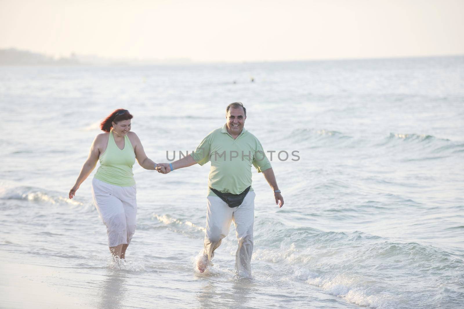 happy senior mature elderly people couple have romantic time on beach at sunset 