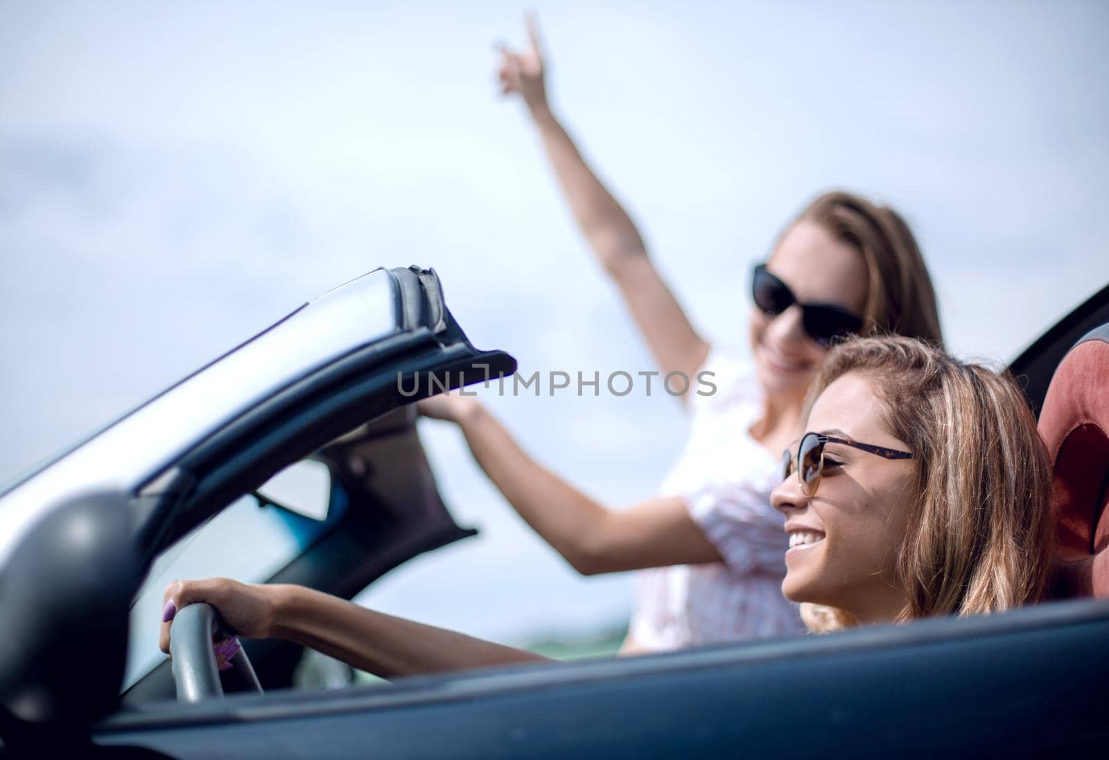 close up.two young women traveling in a convertible car . fashionable lifestyle