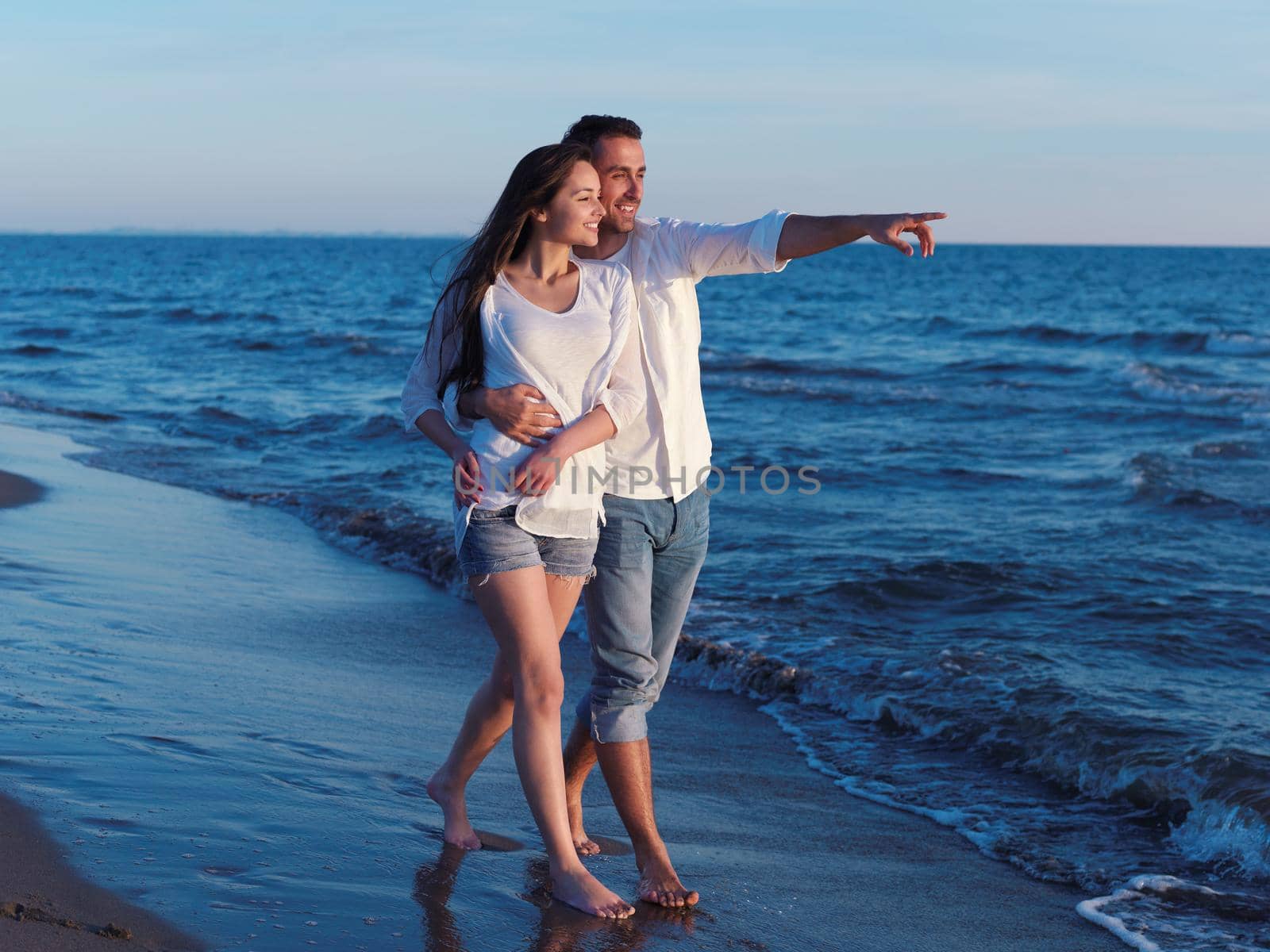 happy young romantic couple in love have fun on beautiful beach at beautiful summer day