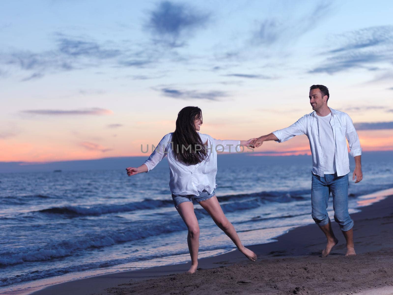 happy young romantic couple in love have fun on beautiful beach at beautiful summer day