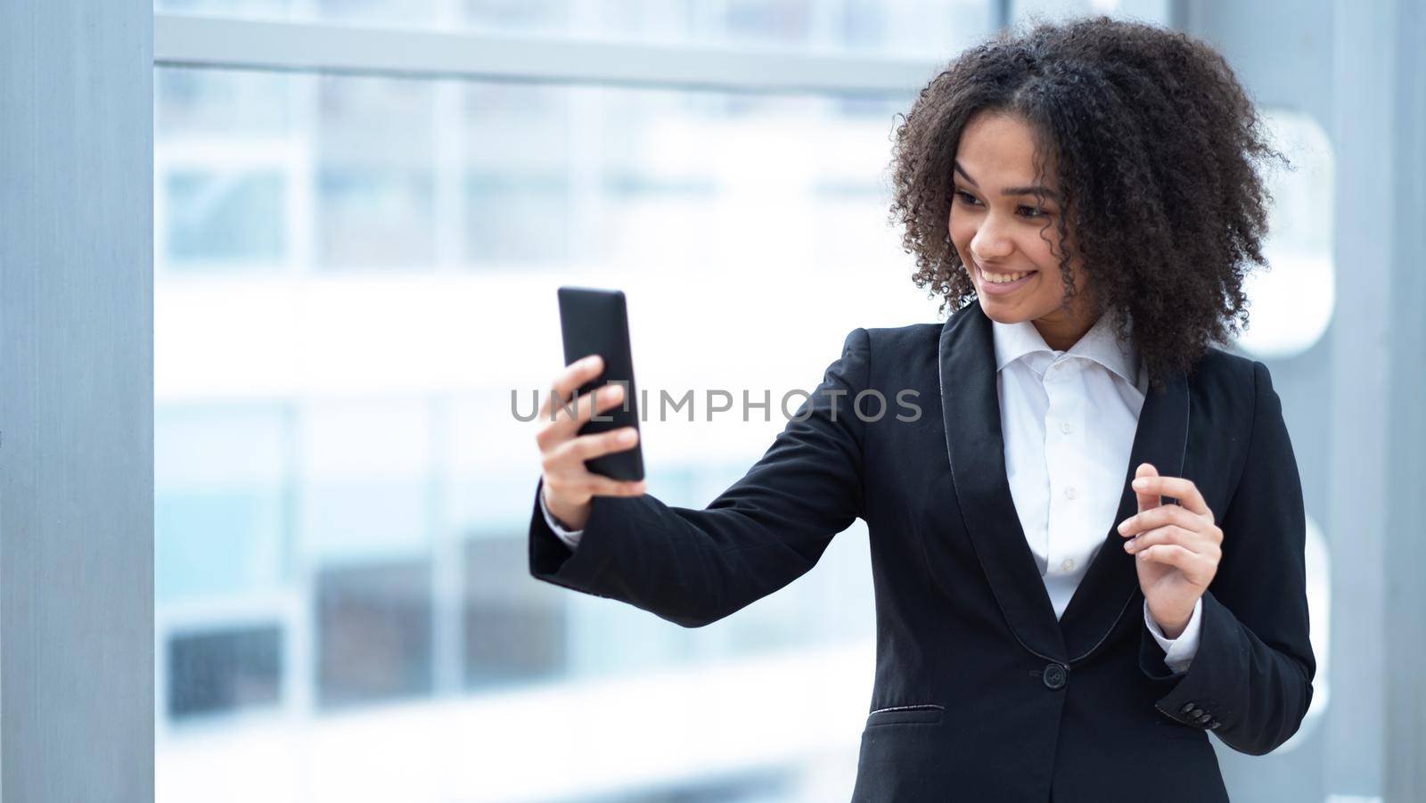 Beautiful African American woman holding cellphone, communication, chatting, girl using smartphone with mobile app smiling and talking