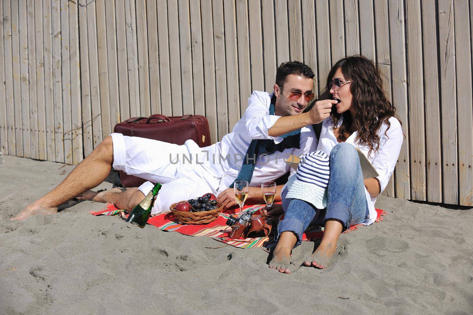 happy young couple enjoying  picnic on the beach and have good time on summer vacations