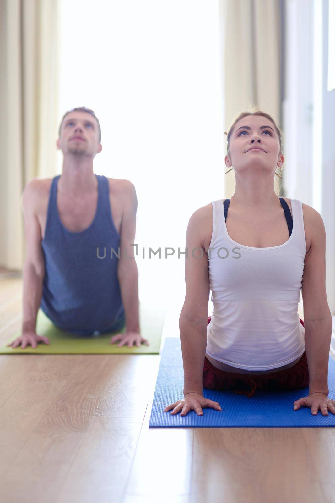 Young healthy couple in yoga position on white background by lenetstan