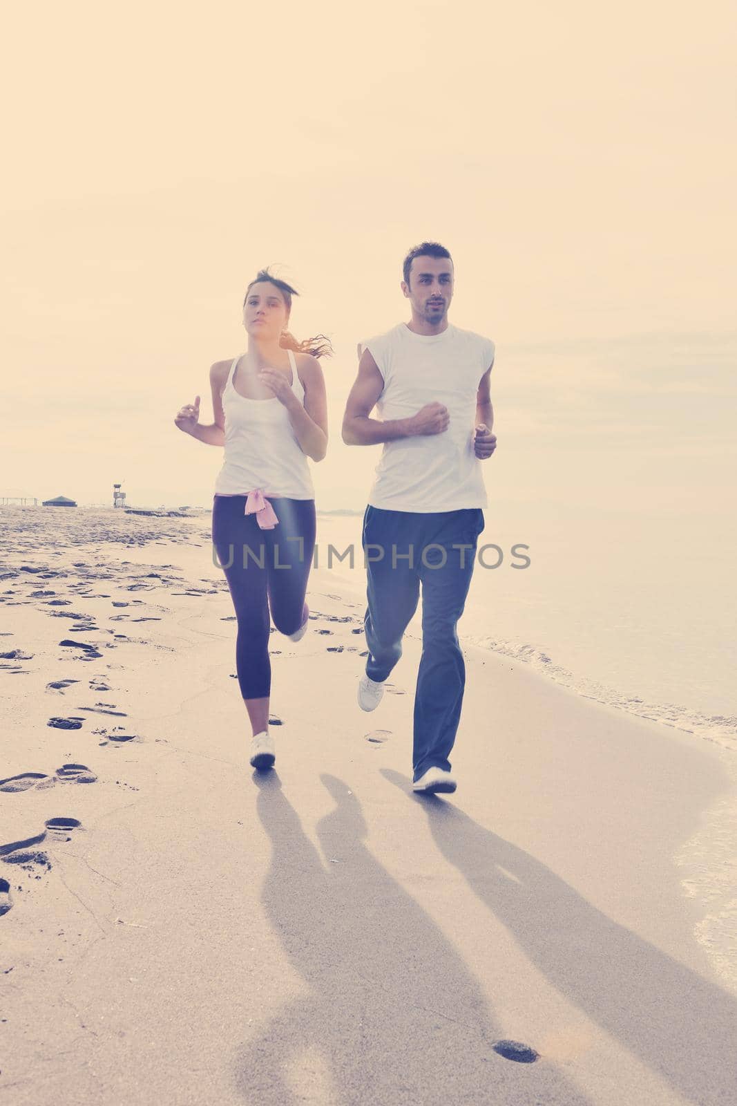 couple jogging on the beach by dotshock