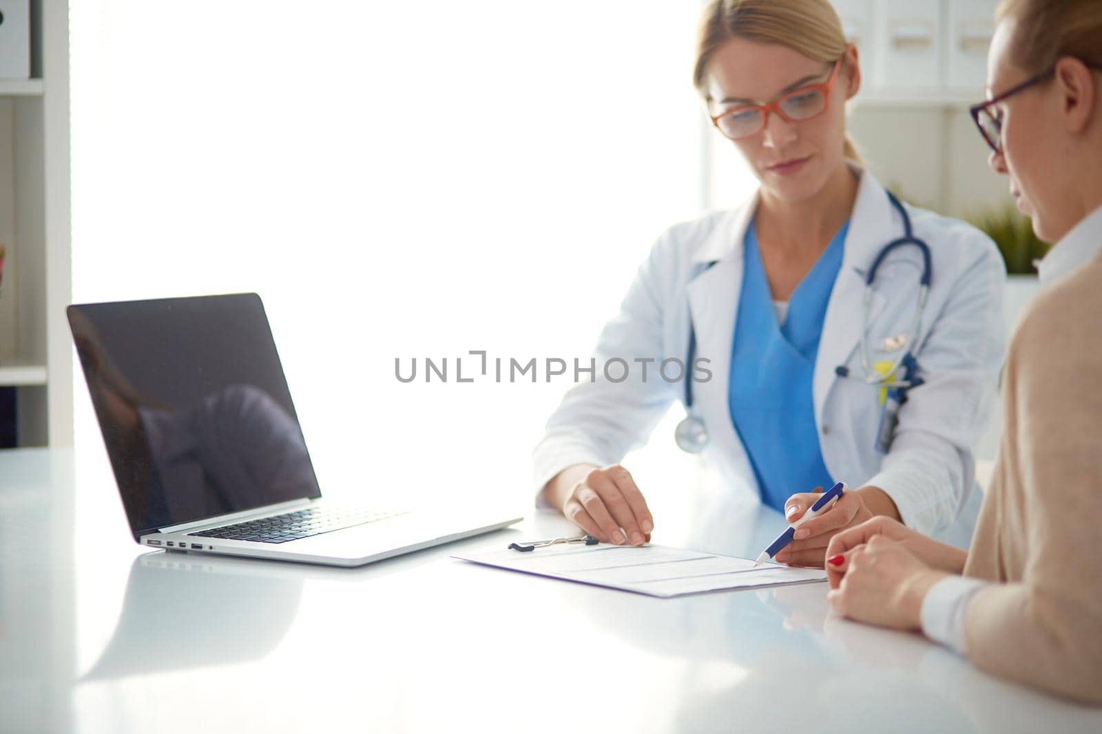Doctor and patient couple are discussing something,sitting on the desk