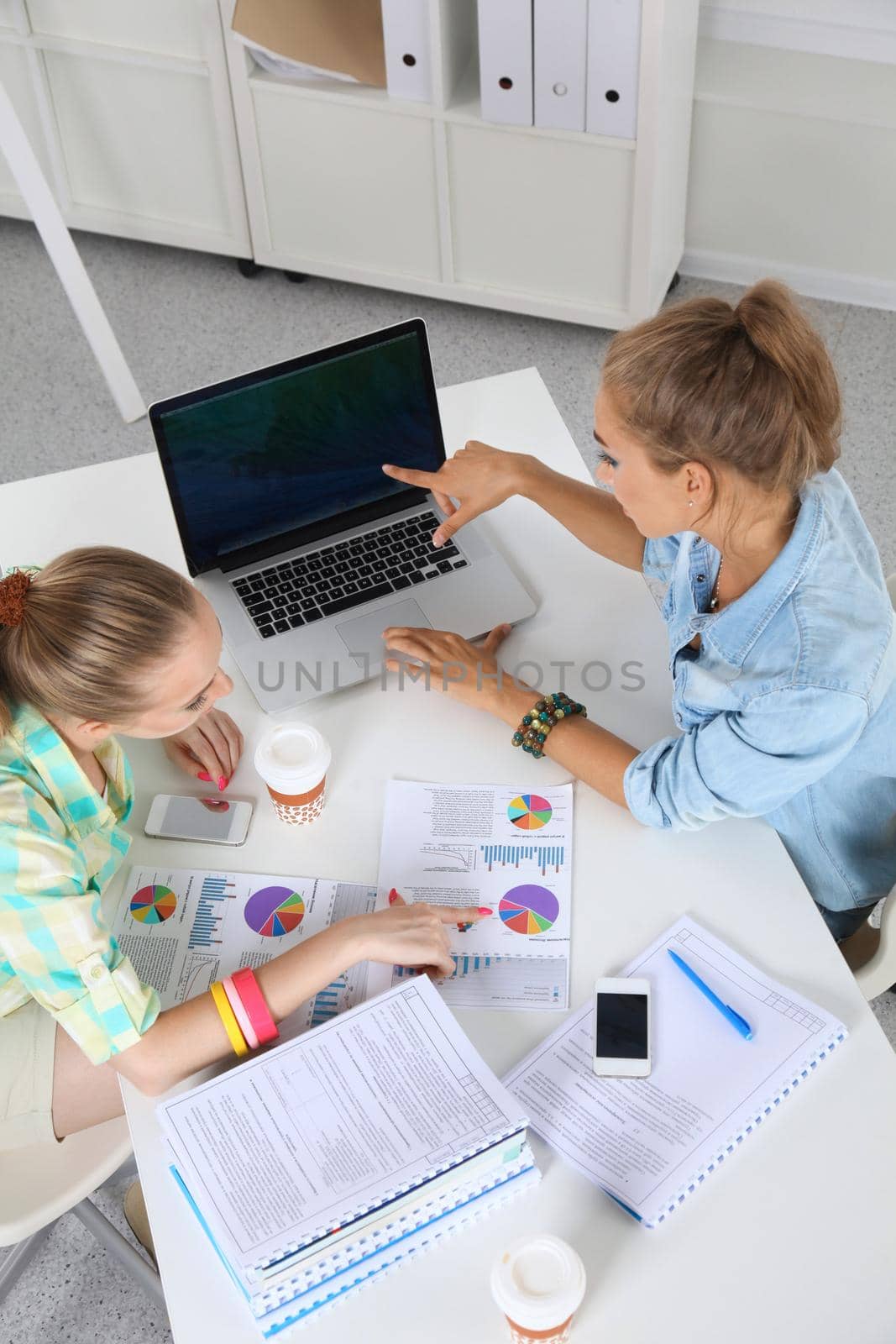 Two women working together at office, sitting