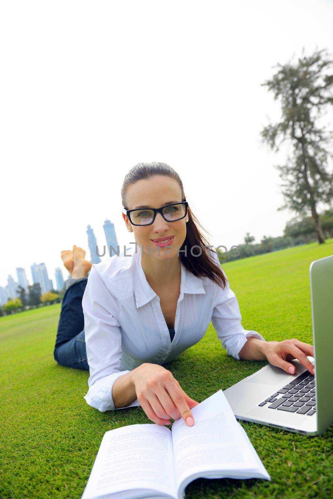 happy young student woman with laptop in city park study