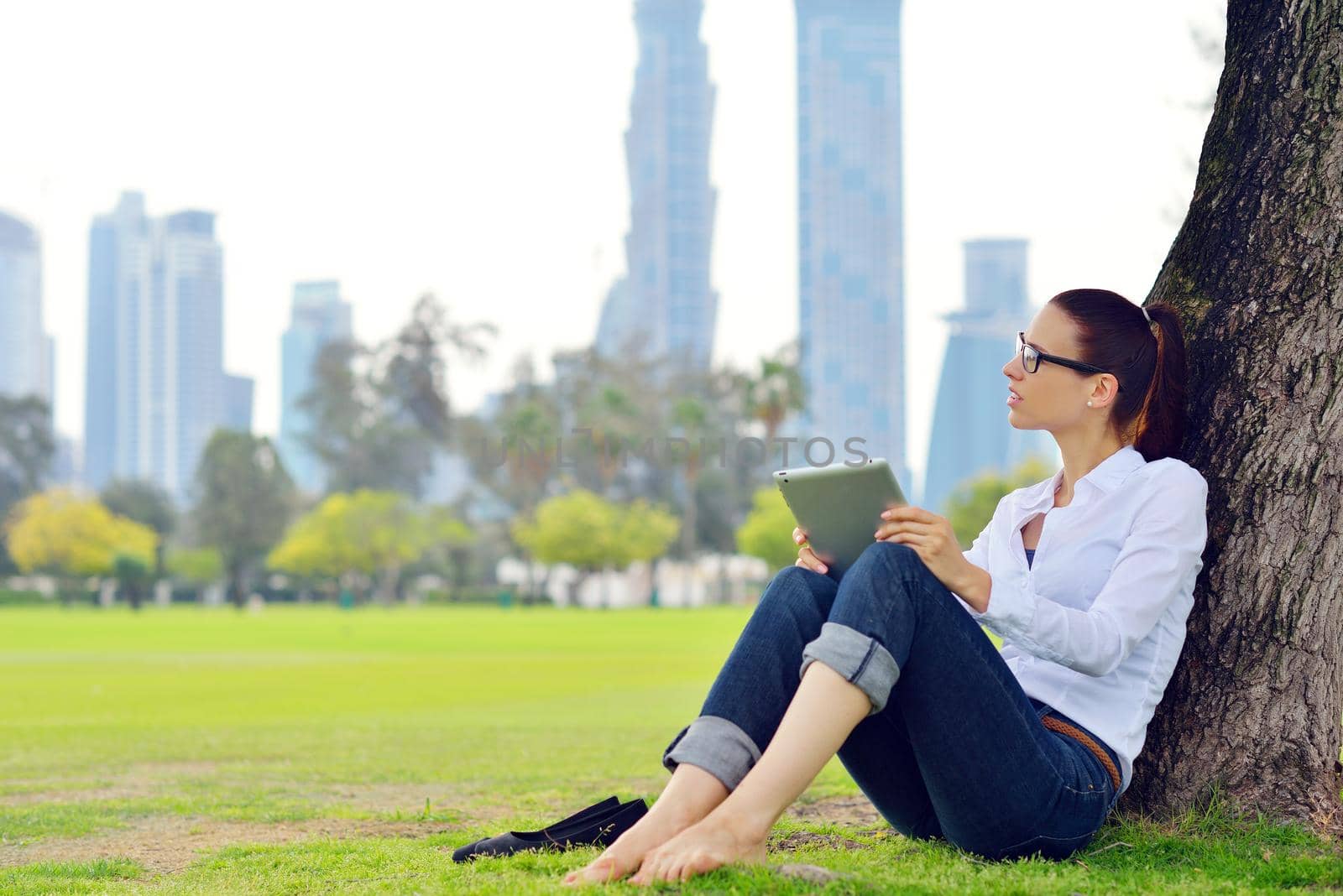 Beautiful young woman with  tablet in park by dotshock