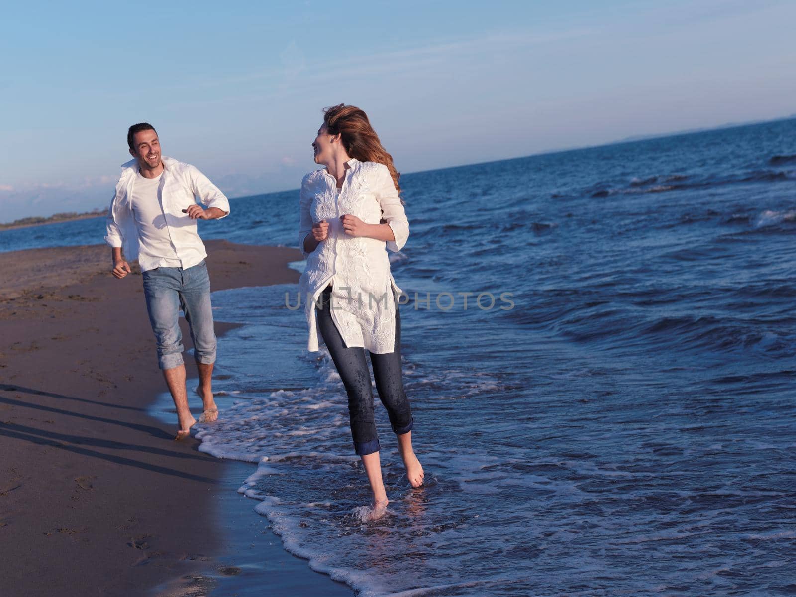 happy young romantic couple in love have fun on beautiful beach at beautiful summer day