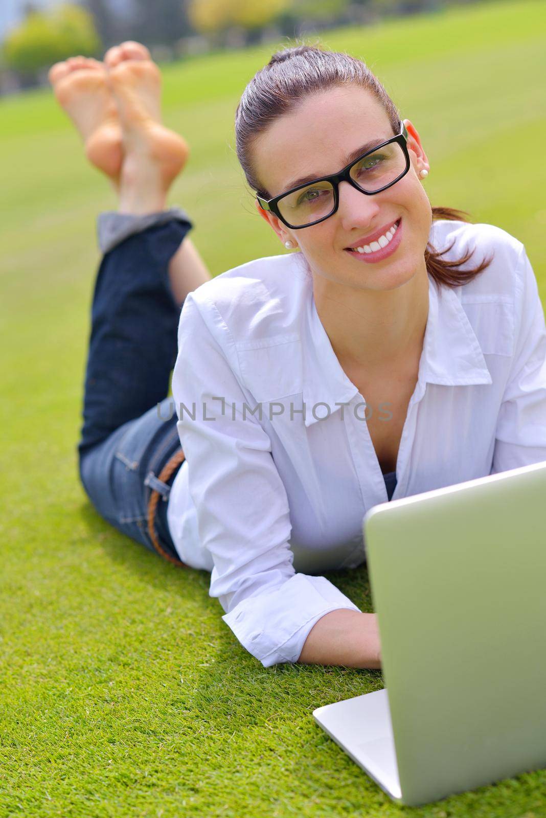 happy young student woman with laptop in city park study