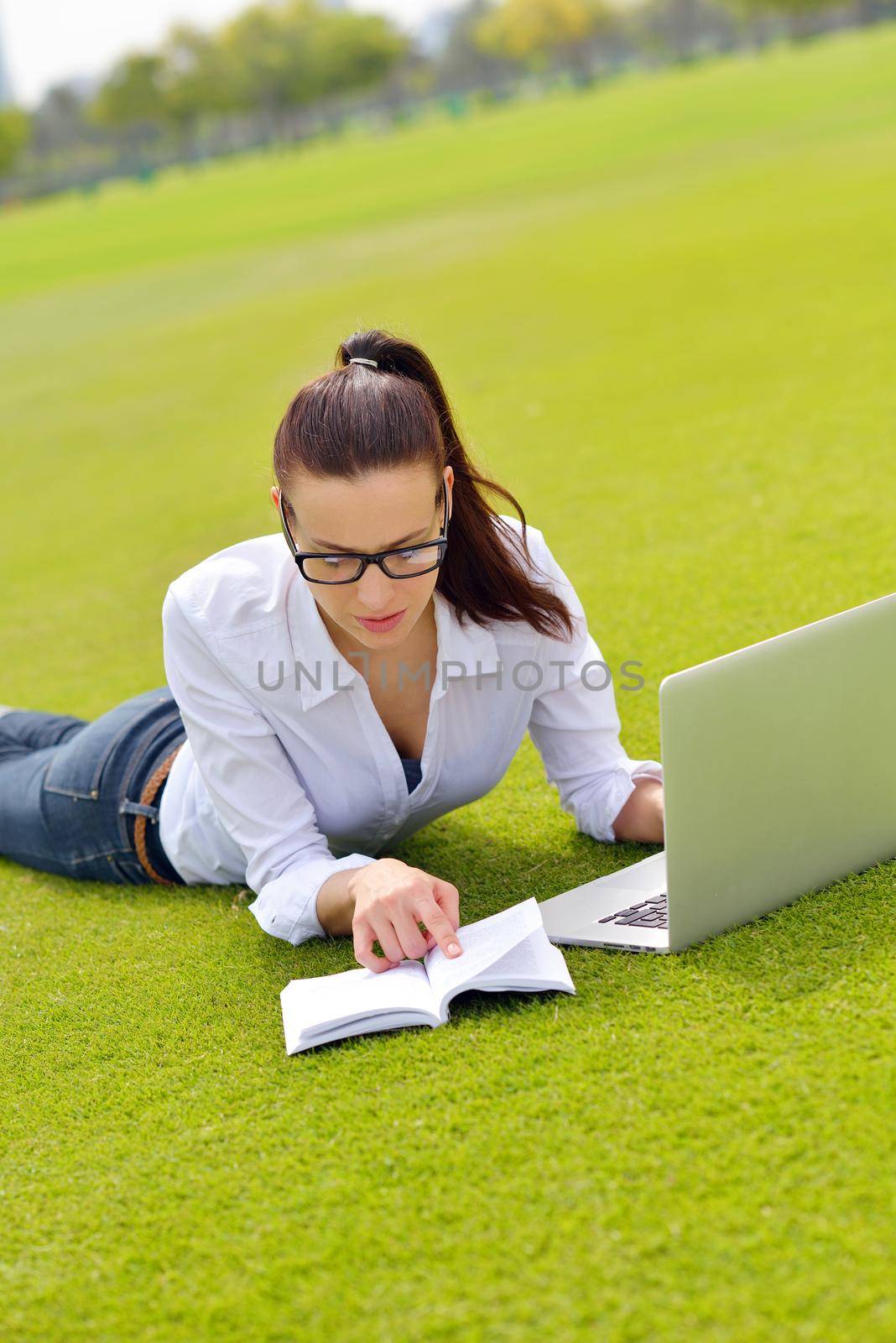 happy young student woman with laptop in city park study