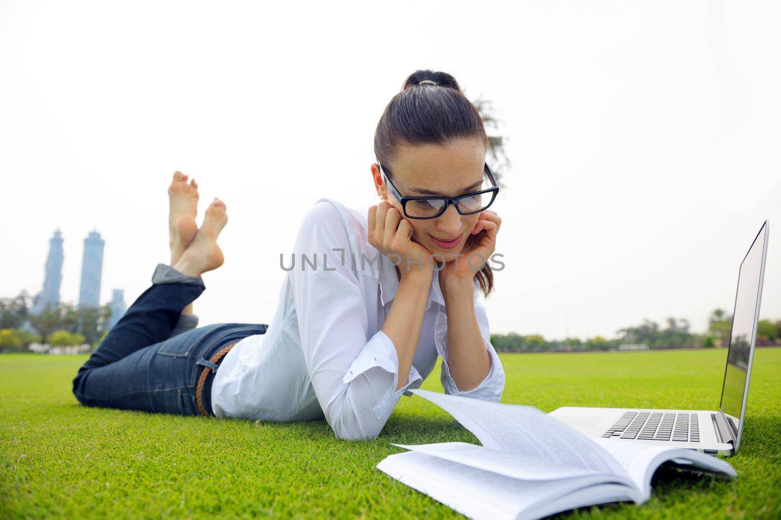 happy young student woman with laptop in city park study