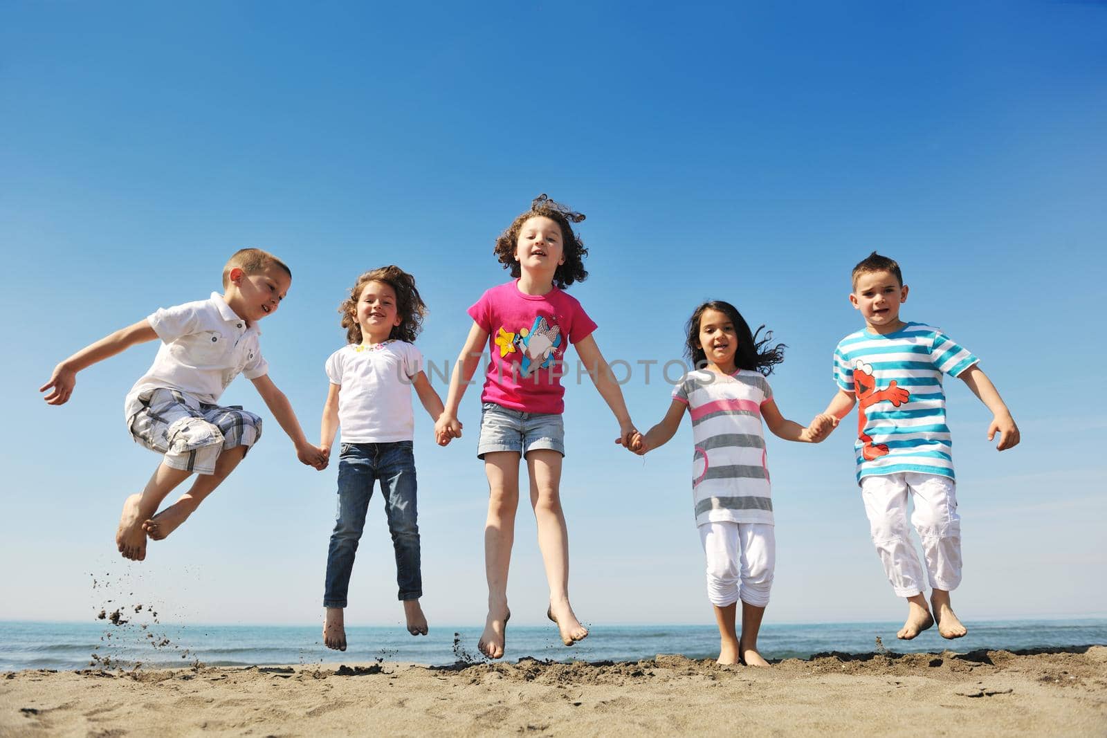 happy young  people group have fun on beach by dotshock