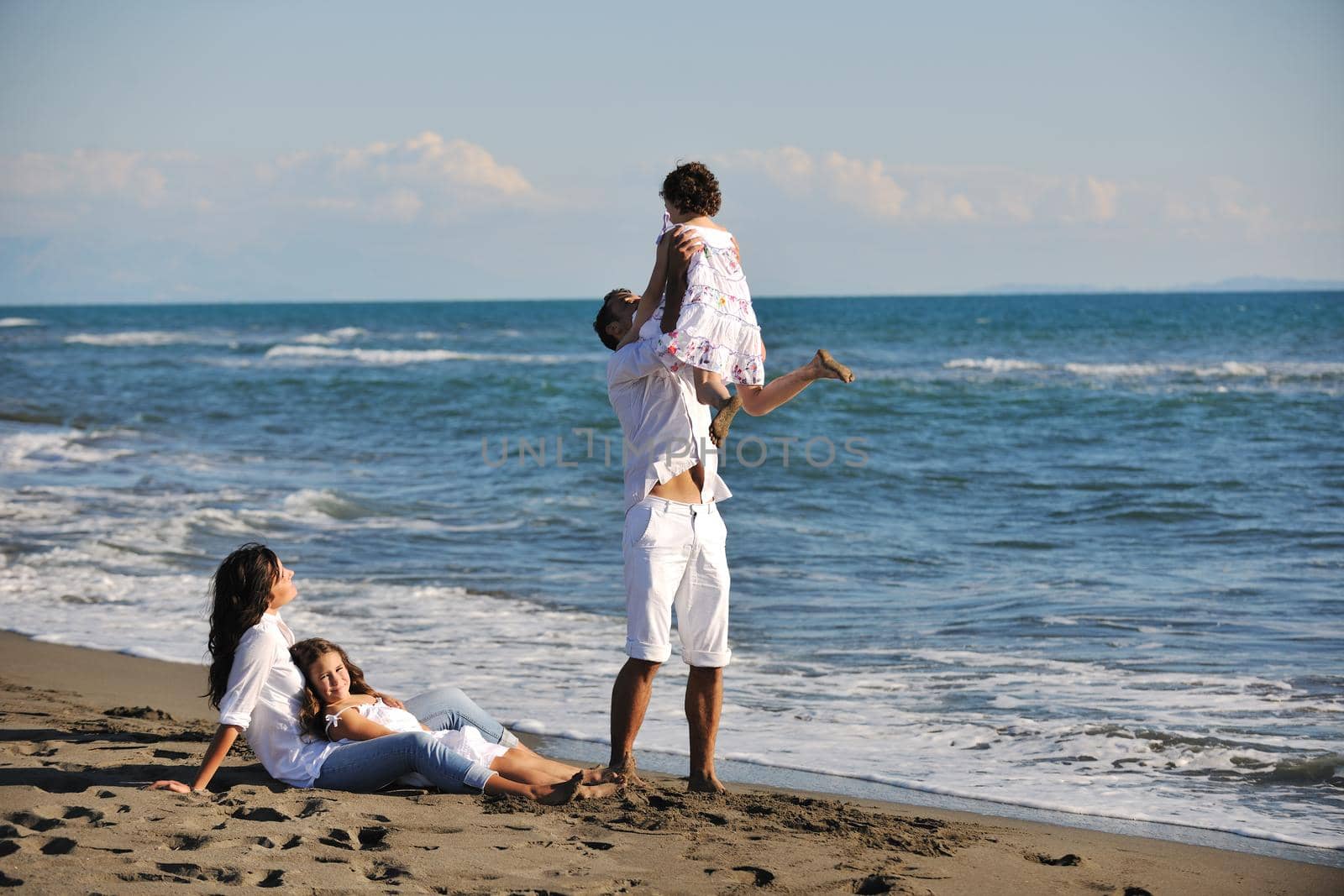 happy young family in white clothing have fun at vacations on beautiful beach 