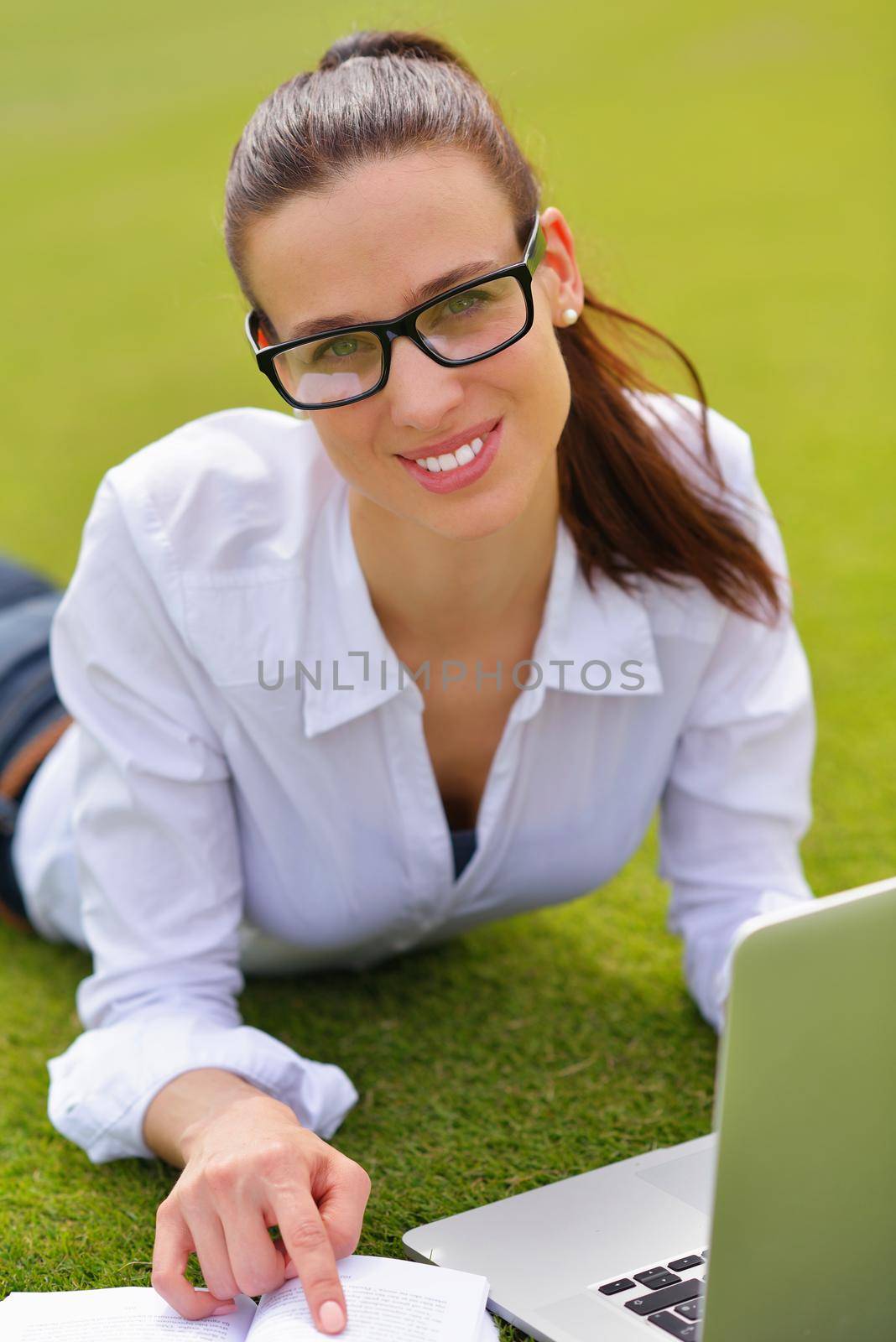 happy young student woman with laptop in city park study