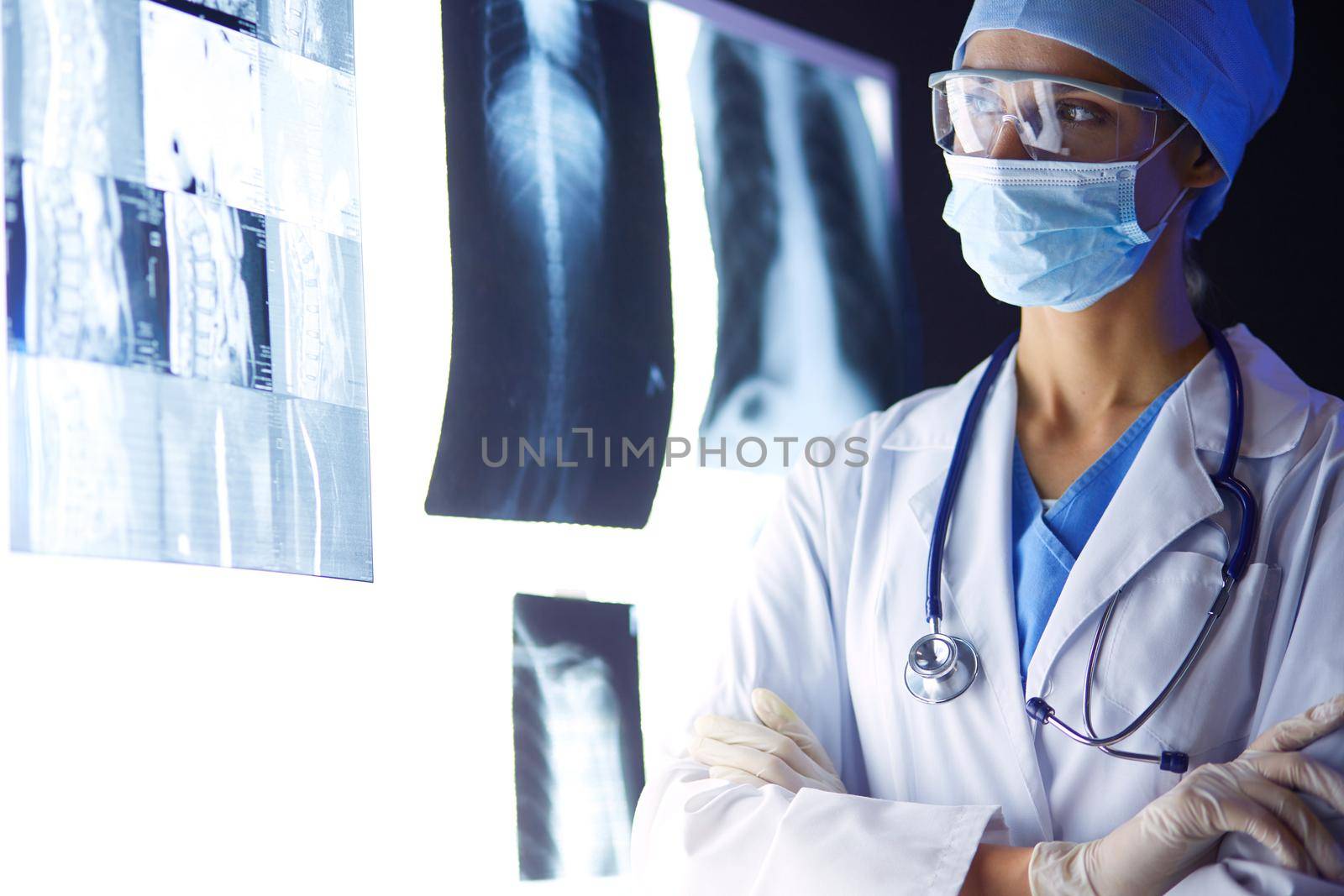 Image of attractive woman doctor looking at x-ray results. by lenetstan