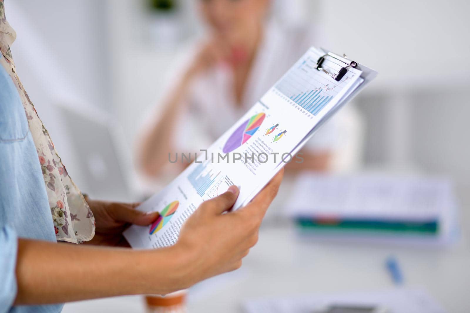 Young woman holding folder in hands .