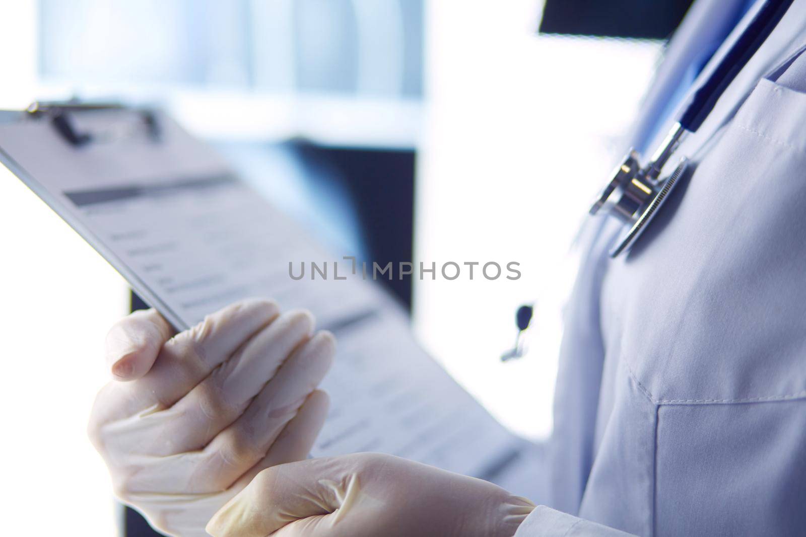 Image of attractive woman doctor looking at x-ray results. by lenetstan