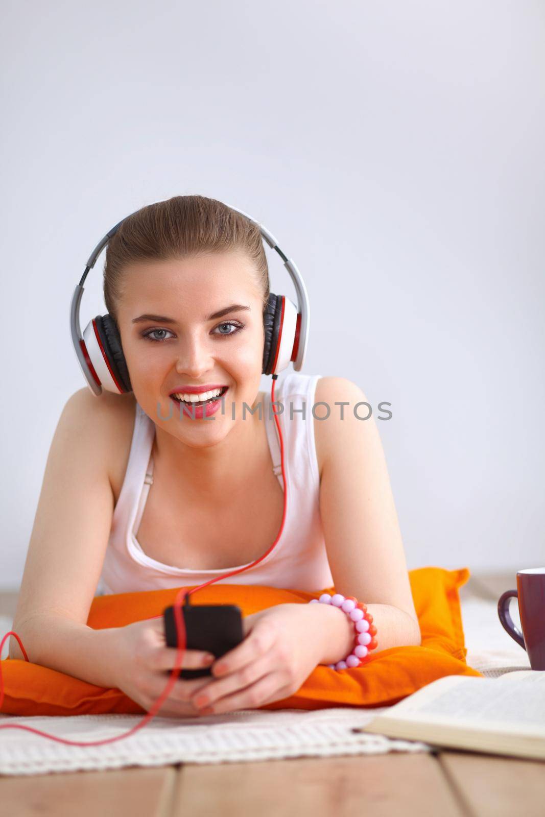 Young woman lying on floor and listen to music by lenetstan