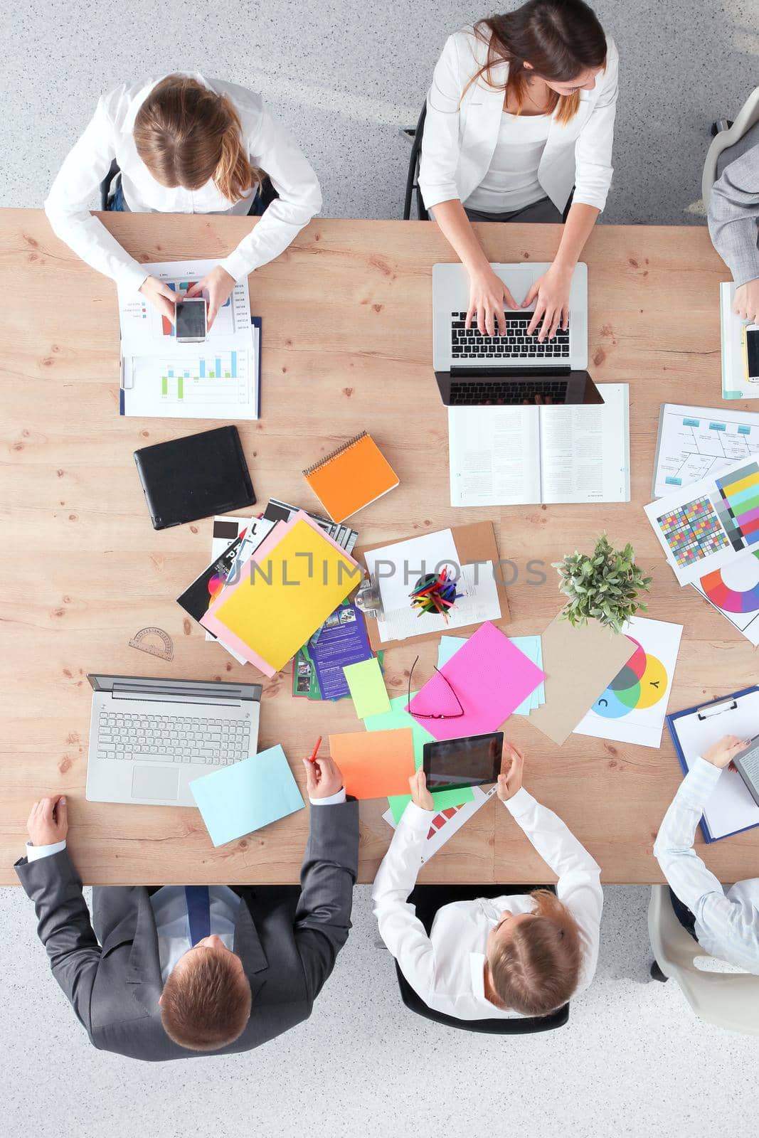 Business people sitting and discussing at business meeting, in office by lenetstan