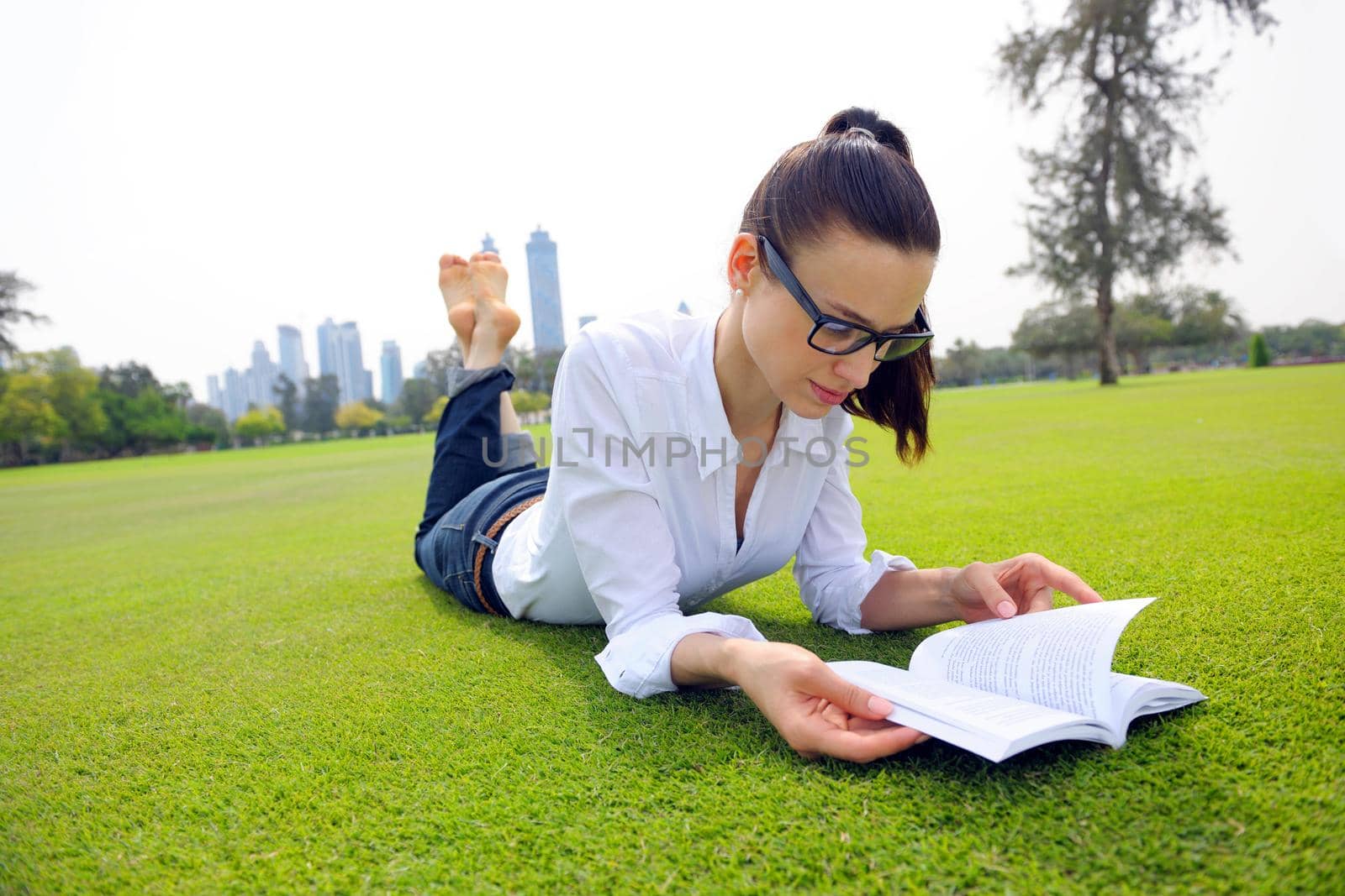 Young student woman reading a book and study in the park