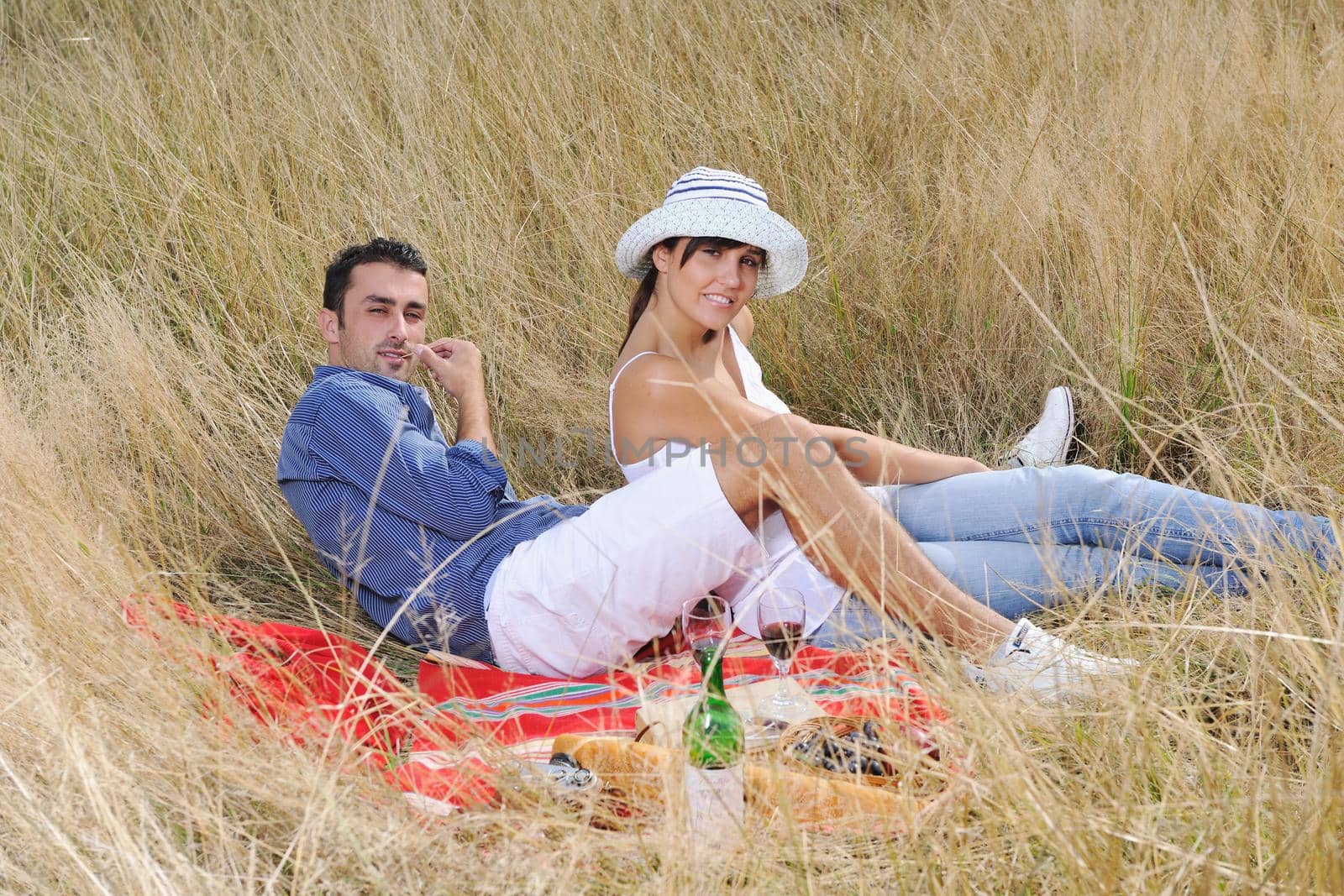 happy young couple enjoying  picnic on the countryside in the field  and have good time