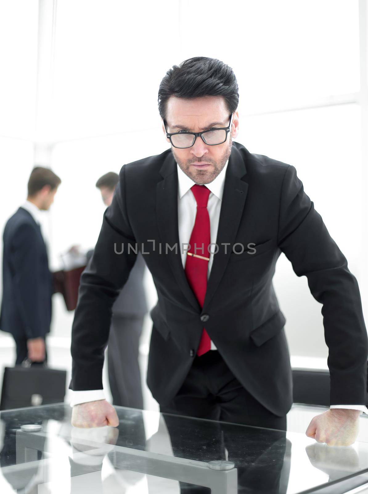 Portrait of angry concentrated director standing near desk by asdf