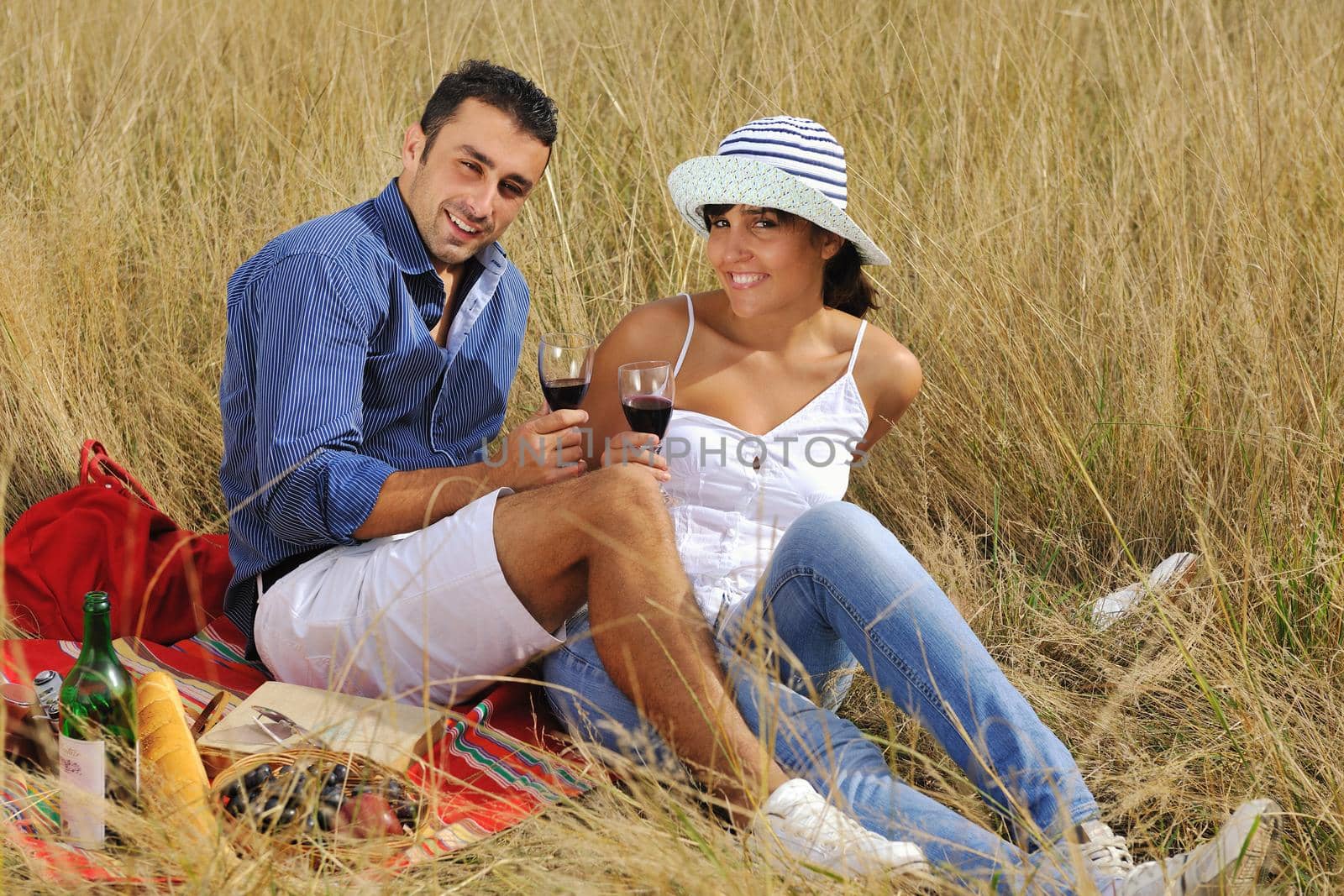 happy young couple enjoying  picnic on the countryside in the field  and have good time