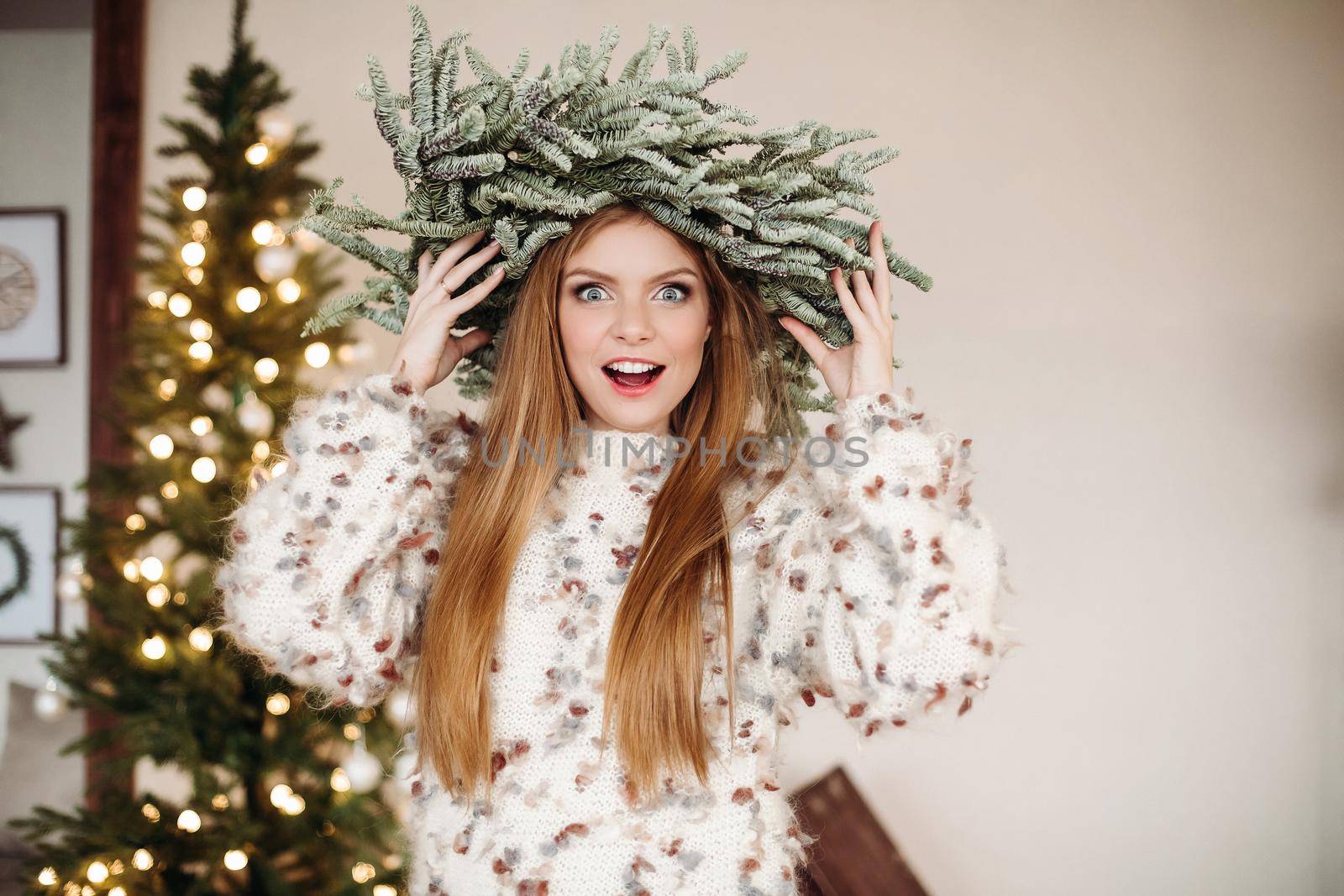 Excited girl in Christmas wreath on head. by StudioLucky