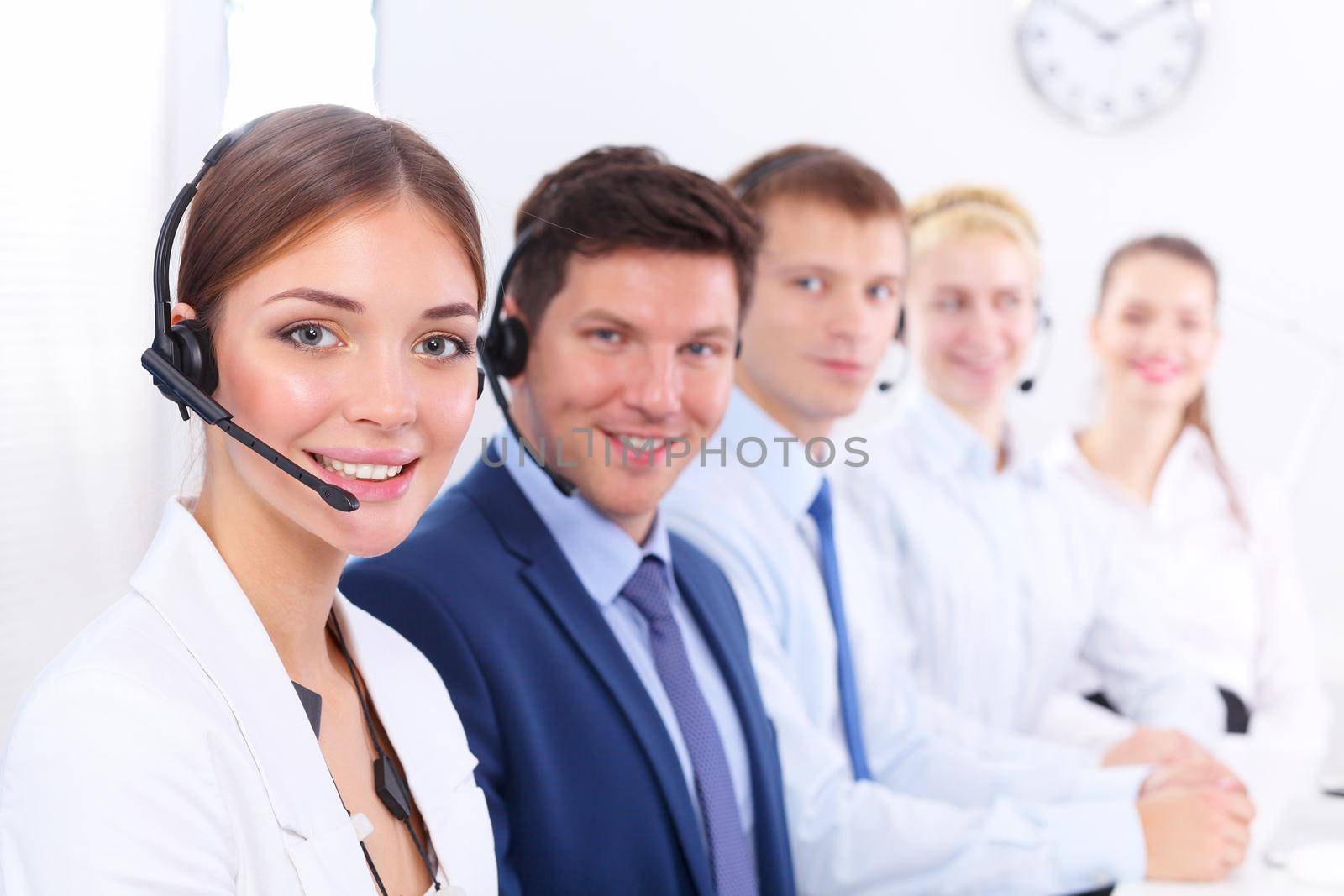 Attractive positive young businesspeople and colleagues in a call center office