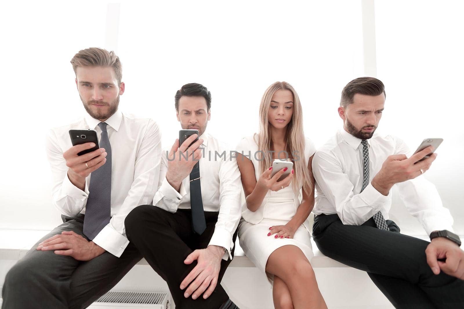 close up.Business people using smartphones sitting in a row by asdf