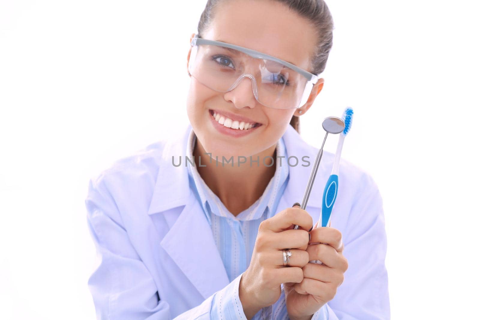 Beautiful female dentist doctor holding and showing a toothbrush isolated on a white background. Dentist doctor by lenetstan