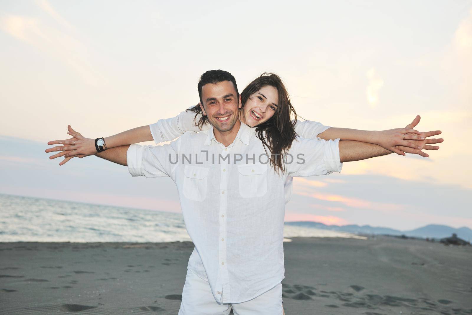 happy young couple have fun and romantic moments on beach at summer season and representing happynes and travel concept