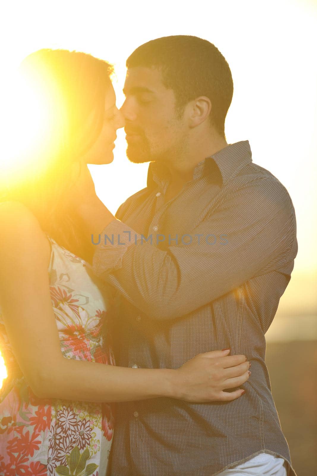 happy young couple have romantic time on beach at sunset