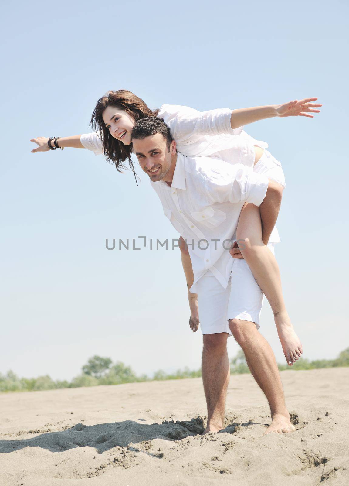 happy young couple have fun and romantic moments on beach at summer season and representing happynes and travel concept