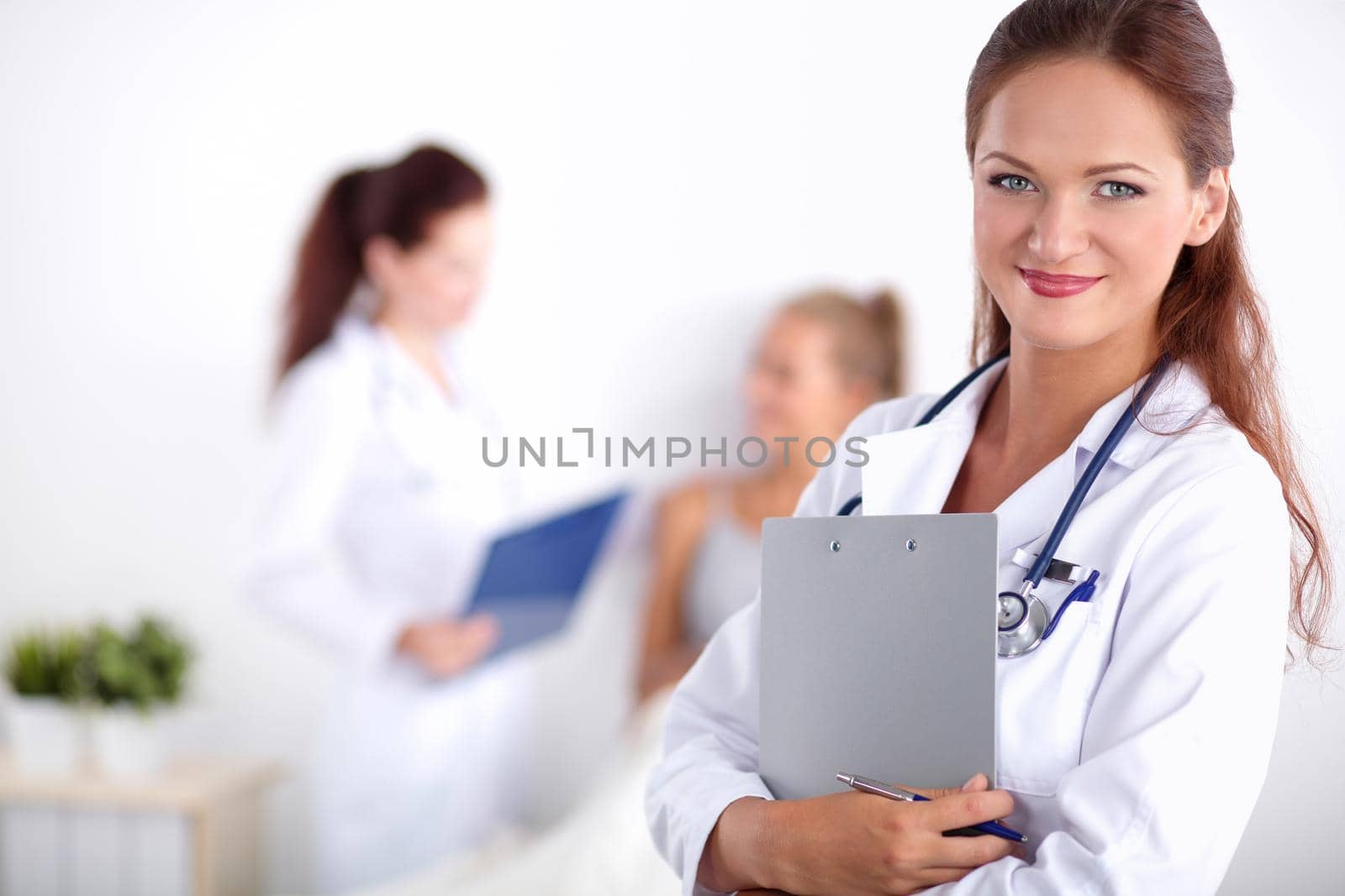 Smiling female doctor with a folder in uniform standing