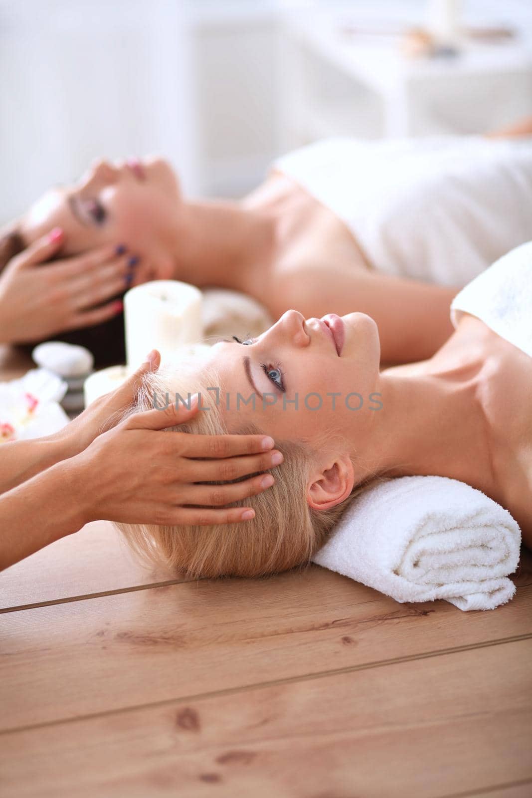 Two young beautiful women relaxing and enjoying at the spa center by lenetstan