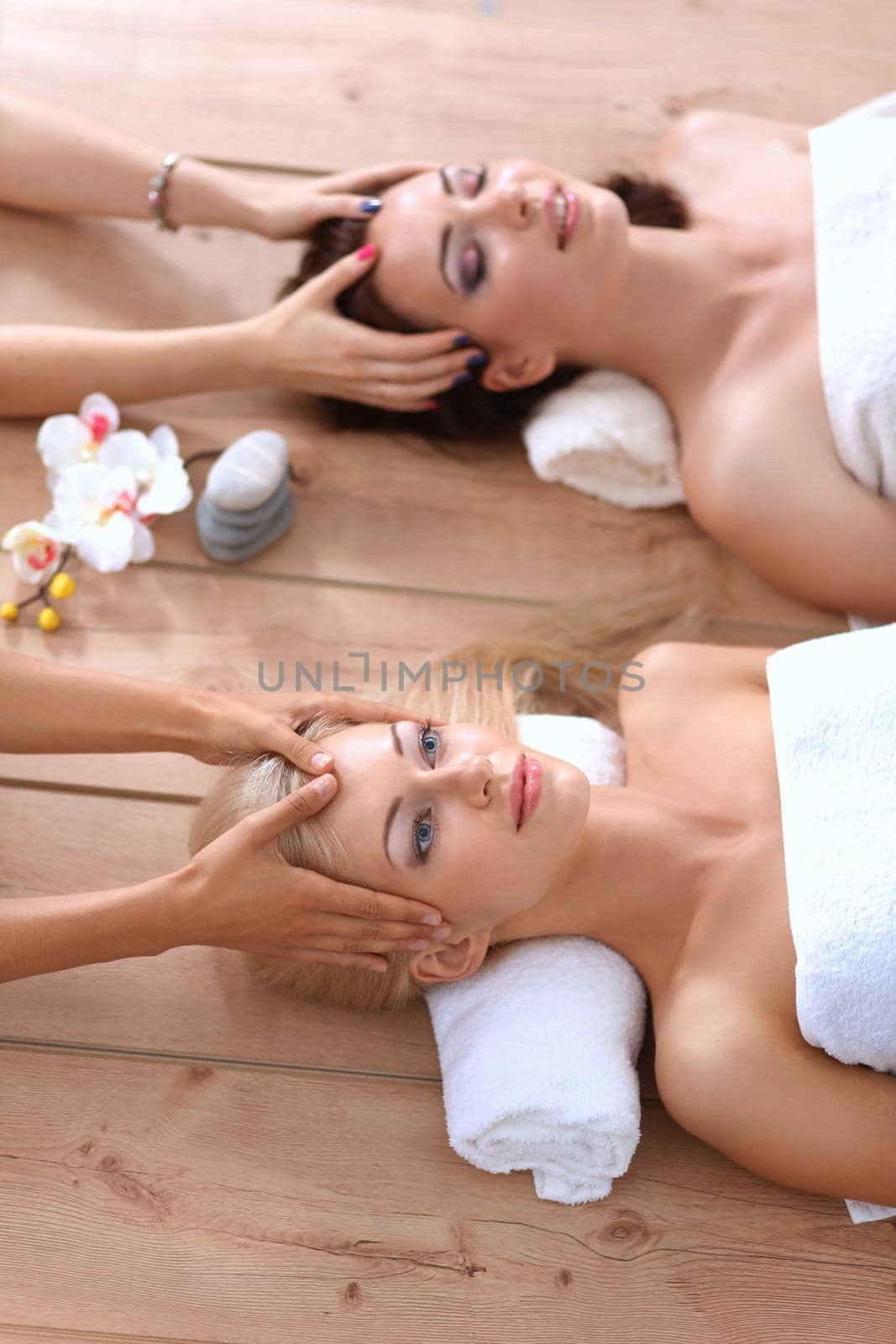 Two young beautiful women relaxing and enjoying at the spa center by lenetstan