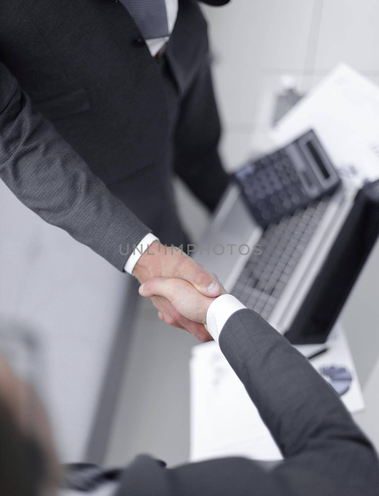 close up.handshake trading partners over the desktop.business background