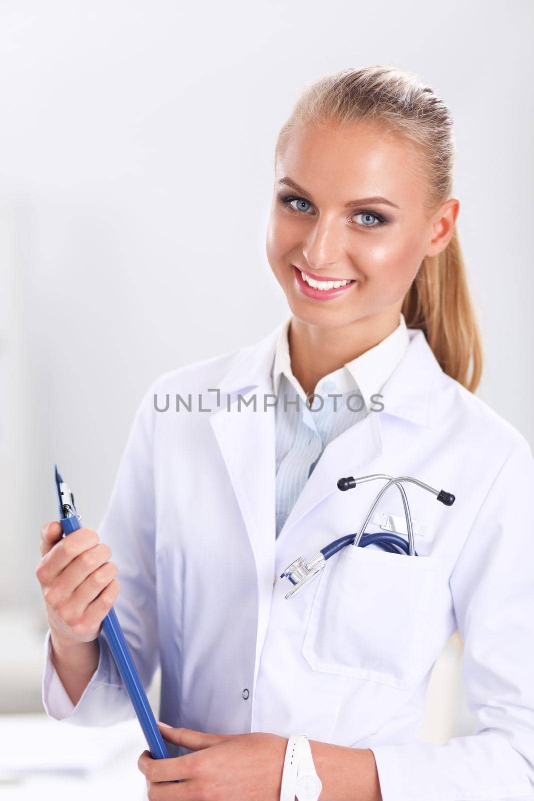 Smiling female doctor with a folder in uniform standing