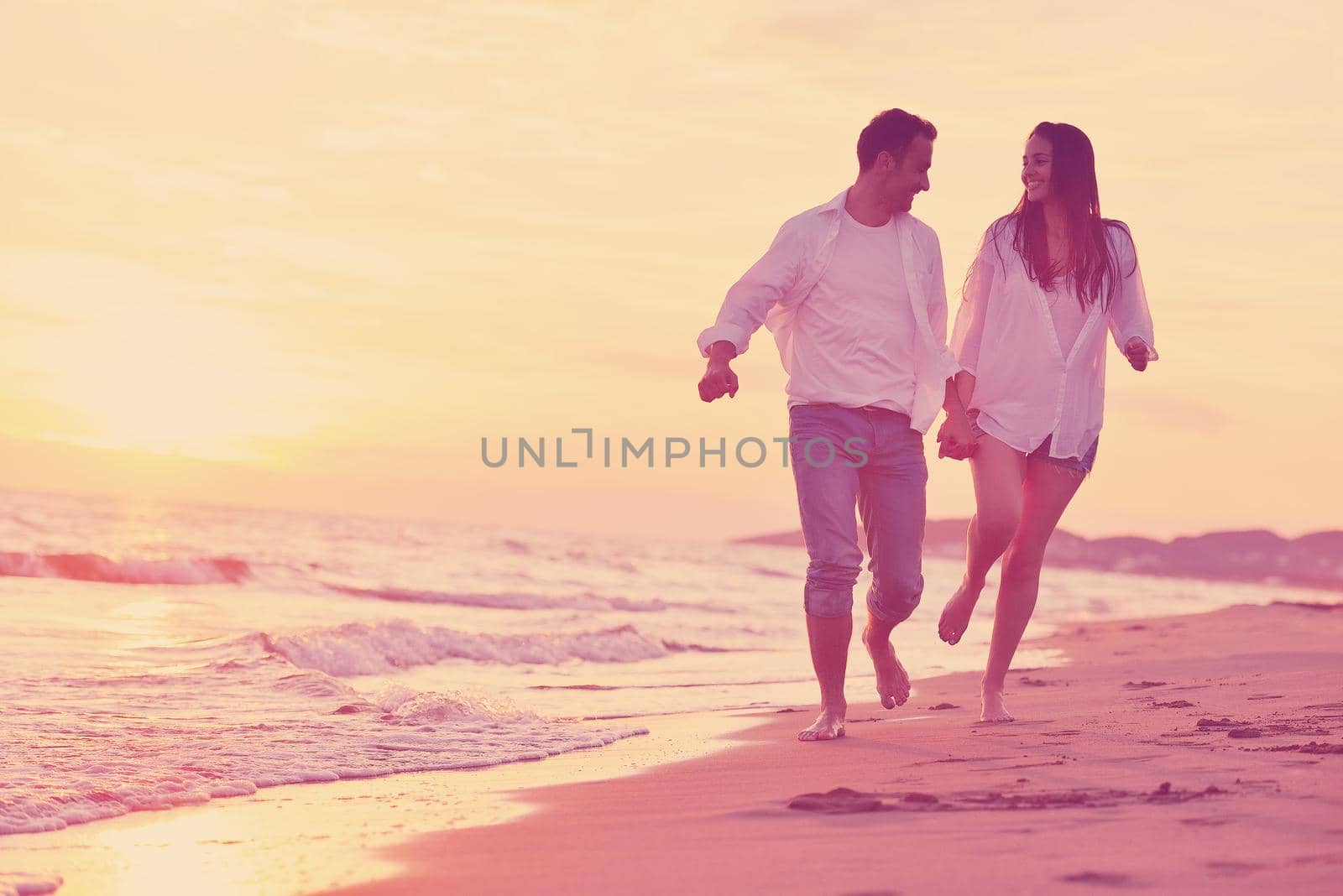 happy young romantic couple in love have fun on beautiful beach at beautiful summer day